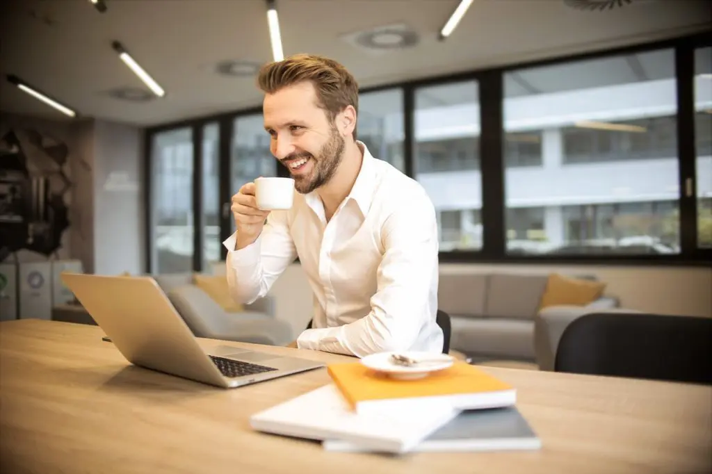 depth of field photo of man sitting on chair while holding 927451