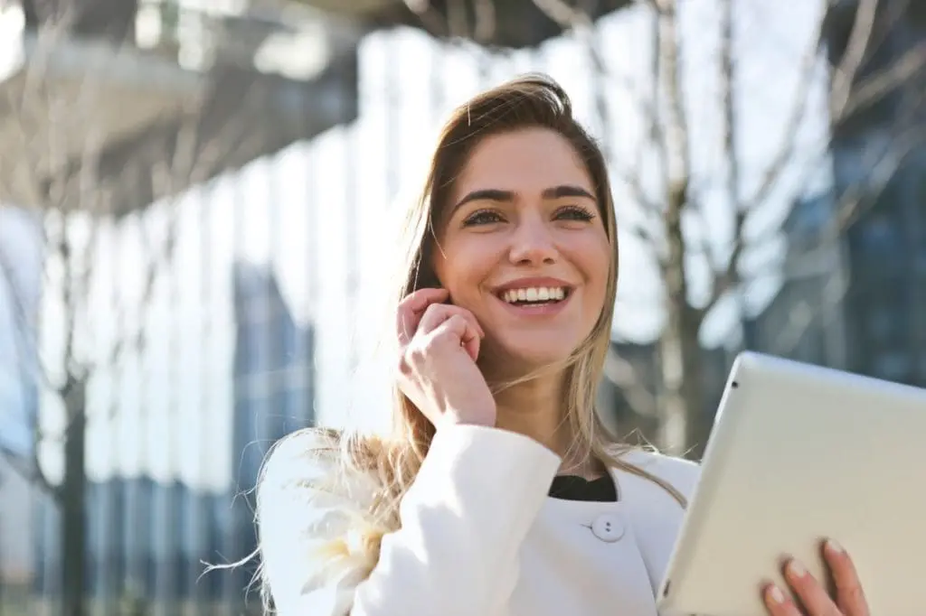 woman in white blazer holding tablet computer 789822