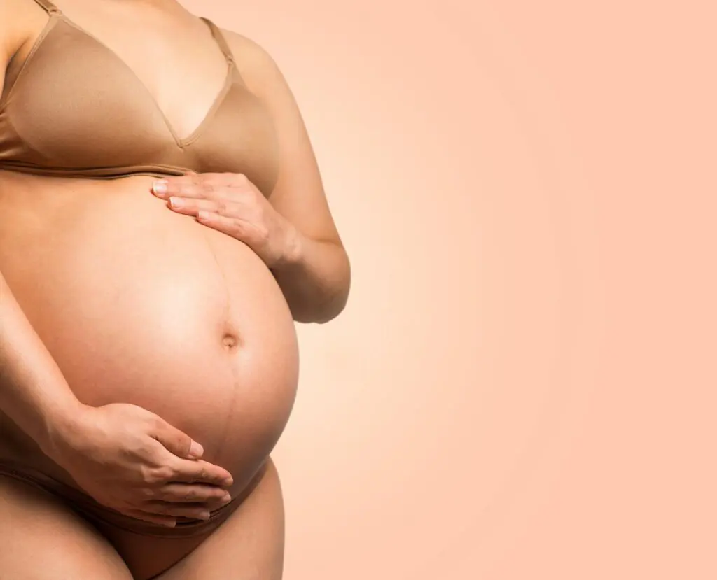 A pregnant woman caressing her stomach