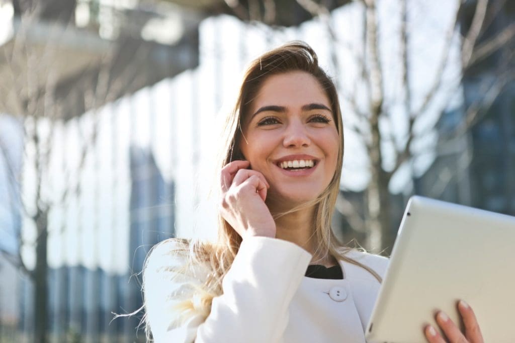 woman in white blazer holding tablet computer 789822