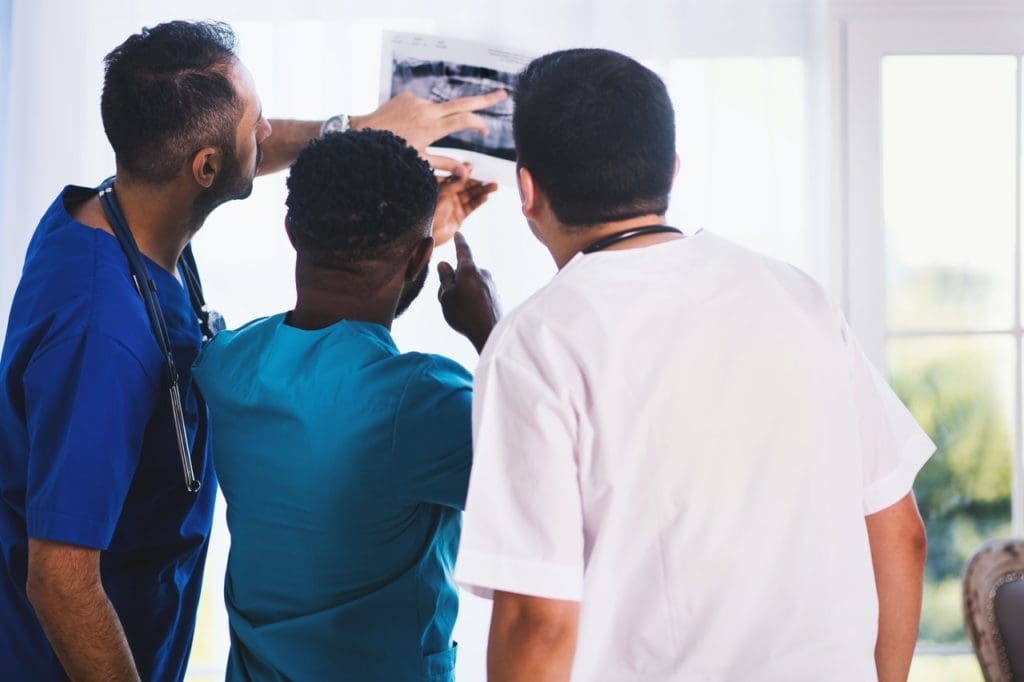 three person looking at x ray result 1170979 2